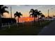Sunset over calm water with palm trees and a pier at 4528 106Th W St, Bradenton, FL 34210
