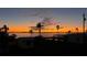 Sunset over calm water with palm trees and houses at 4528 106Th W St, Bradenton, FL 34210