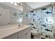 Bathroom with a light gray vanity, decorated mirror, and shark-themed shower curtain at 521 Cummings St, Sarasota, FL 34242