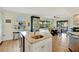 Kitchen island featuring granite counters, sink, storage, and proximity to dining area and backyard access at 521 Cummings St, Sarasota, FL 34242