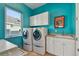 Bright laundry room with washer, dryer, and ample cabinetry at 5531 2Nd Avenue W Cir, Palmetto, FL 34221