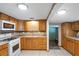 Kitchen with wood cabinets, white appliances, and a center island at 6 Seminole Dr, Bradenton, FL 34208