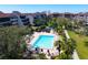 Aerial view of a community pool, lush landscaping, and surrounding condo buildings at 6283 Midnight Pass Rd # 6283, Sarasota, FL 34242