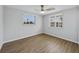 Well-lit bedroom with wood-look floors and dual windows at 635 Jamaica E Cir, Apollo Beach, FL 33572