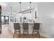 Modern kitchen with white cabinets and a breakfast bar with three stools at 6418 Margarita Shores Ln, Apollo Beach, FL 33572