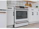Modern range with copper accents in a bright white kitchen at 6418 Margarita Shores Ln, Apollo Beach, FL 33572