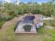 Aerial view of house with solar panels, pool, and lush landscaping at 6488 Ponce De Leon Blvd, North Port, FL 34291