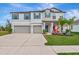 Two-story home with a two-car garage and landscaped lawn at 7404 Mill Hopper Ct, Palmetto, FL 34221