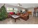 Living room with large windows, tile floor, and leather sofas at 7404 Mill Hopper Ct, Palmetto, FL 34221