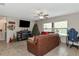 Living room with large windows, fireplace, tv, and leather sofa at 7404 Mill Hopper Ct, Palmetto, FL 34221