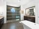 Spa-like bathroom with walk-in shower, freestanding tub, and dark tile at 8325 Lindrick Ln, Bradenton, FL 34202