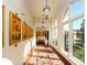 Elegant hallway with hardwood floors, artwork, and large windows at 8325 Lindrick Ln, Bradenton, FL 34202