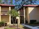 Two-story condo building with walkway, landscaping, and palm trees at 1111 Faith W Cir # 2003, Bradenton, FL 34212