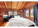 Bright bedroom with wood walls, white bedding, and large windows at 14900 Coker Gully Rd, Myakka City, FL 34251