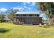 Farmhouse with a screened porch, two Adirondack chairs, and a large yard at 14900 Coker Gully Rd, Myakka City, FL 34251