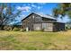 Rustic farmhouse with screened porch, large star detail, and a spacious yard at 14900 Coker Gully Rd, Myakka City, FL 34251