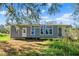 Gray farmhouse exterior with a covered porch and large windows at 14900 Coker Gully Rd, Myakka City, FL 34251
