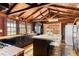 Modern kitchen with dark cabinetry, large island, wood beams, and wood floors at 14900 Coker Gully Rd, Myakka City, FL 34251