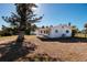 Rear exterior of single-story home featuring a partially fenced yard and mature shade trees at 15815 Redington Dr, Redington Beach, FL 33708