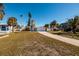 Charming single-story home with a large front yard, long driveway, and tropical palm trees at 15815 Redington Dr, Redington Beach, FL 33708