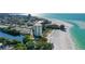 Wonderful aerial view of a white condo building situated on a white sandy beach with turquoise water at 19 Whispering Sands Dr # 301, Sarasota, FL 34242