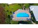 Aerial view of a community pool surrounded by lush landscaping, lounge chairs, and shaded seating areas at 19 Whispering Sands Dr # 301, Sarasota, FL 34242