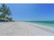 Picturesque scene of a white sand beach meeting the turquoise ocean waters at 19 Whispering Sands Dr # 301, Sarasota, FL 34242