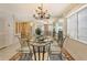 Dining room with chandelier, mirrored wall, seating for six, and views to the living room and balcony at 19 Whispering Sands Dr # 301, Sarasota, FL 34242