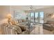 Bright living room with comfortable seating and access to the balcony overlooking the beach at 19 Whispering Sands Dr # 301, Sarasota, FL 34242