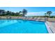 Community pool with lounge chairs at 19 Whispering Sands Dr # 301, Sarasota, FL 34242