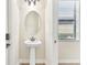 Powder room with pedestal sink and oval mirror at 20345 Reale Cir, Venice, FL 34293