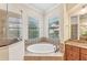 Elegant bathroom with soaking tub, walk-in shower, and granite vanity at 20345 Reale Cir, Venice, FL 34293