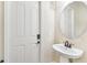 Small half-bath with pedestal sink and round mirror at 20345 Reale Cir, Venice, FL 34293