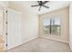 Bright bedroom with carpet flooring, ceiling fan, and large window at 20345 Reale Cir, Venice, FL 34293