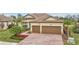 Two-story house with brown garage doors and brick driveway at 20345 Reale Cir, Venice, FL 34293