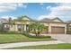 House exterior with a two-car garage and palm trees at 20345 Reale Cir, Venice, FL 34293