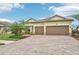 House exterior with a two-car garage and palm trees at 20345 Reale Cir, Venice, FL 34293