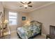 Cozy bedroom featuring a ceiling fan, a comfortable bed, and natural light from the window at 2479 Brassica Dr, North Port, FL 34289