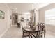 Open-concept dining area with a dark wood table and chairs adjacent to a bright, modern kitchen at 2479 Brassica Dr, North Port, FL 34289