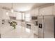 Modern kitchen with white cabinetry, stainless steel appliances, and a stylish backsplash at 2479 Brassica Dr, North Port, FL 34289
