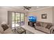 Relaxing living room with sliding glass doors, comfortable seating, and a stylish entertainment center at 2479 Brassica Dr, North Port, FL 34289