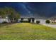 Attractive home exterior at night, showcasing the well-manicured lawn and starry sky at 3866 Pin Oaks St, Sarasota, FL 34232