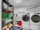 Laundry room with washer, dryer, shelving, and utility sink at 3866 Pin Oaks St, Sarasota, FL 34232