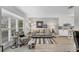 Comfortable living room featuring a gray sofa, patterned armchair, and ample natural light at 3866 Pin Oaks St, Sarasota, FL 34232