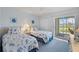 Guest bedroom with two twin beds, balcony access, and tranquil golf course view at 414 Cerromar S Cir # 249, Venice, FL 34293