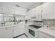 White kitchen with breakfast bar and view of living room at 414 Cerromar S Cir # 249, Venice, FL 34293