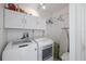 Convenient laundry room with washer, dryer, cabinets, and built-in ironing board at 414 Cerromar S Cir # 249, Venice, FL 34293