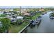 Aerial view of waterfront property with boat lift and lush landscaping at 5981 Emerald Harbor Dr, Longboat Key, FL 34228