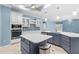 Spacious kitchen with island, stainless steel appliances, and blue cabinetry at 6687 Pitomba St, North Port, FL 34286