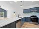 Modern kitchen with blue cabinets, quartz countertops, and stainless steel appliances at 1942 Joyce St, Sarasota, FL 34231